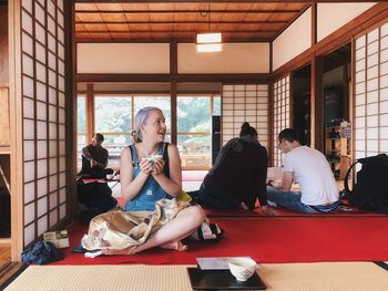 Smiling young woman with tea cup sitting in japanese restaurant