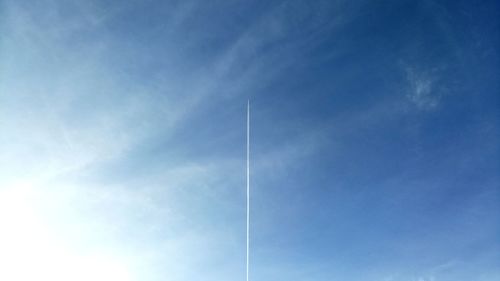 Low angle view of vapor trail against blue sky