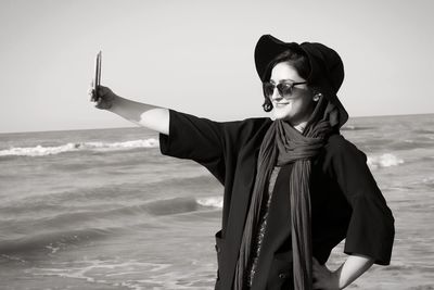 Portrait of young woman standing at beach