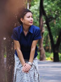 Woman standing on road and looking away