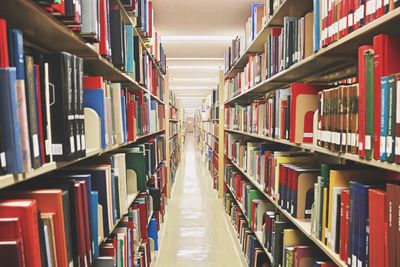Aisle amidst bookshelves in library