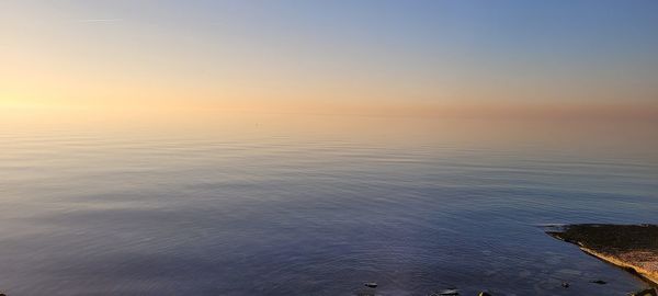 Scenic view of sea against clear sky during sunset