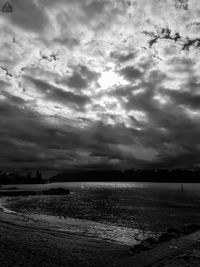 Birds flying over sea against storm clouds