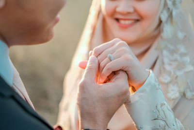 Midsection of couple holding hands