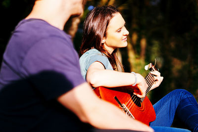 Midsection of man with woman sitting outdoors