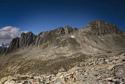 Scenic view of rocky mountains against blue sky