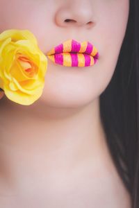 Cropped image of woman with yellow and pink lipstick