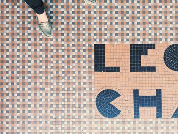 Low section of woman standing on tiled floor