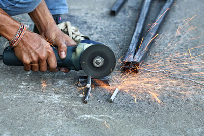 Low section of man cutting metal