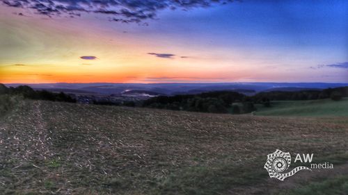 Scenic view of field against sky during sunset