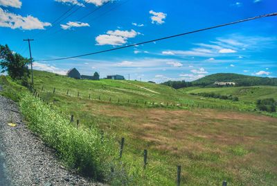 Scenic view of field against cloudy sky