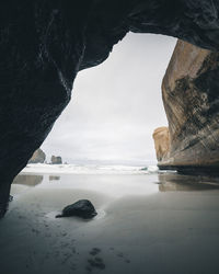 Rock formations by sea against sky