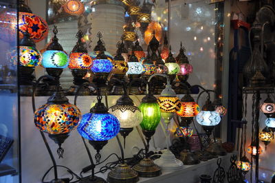 Illuminated lanterns hanging in store for sale