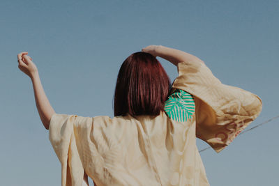 Rear view of woman standing against clear sky