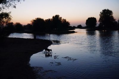 Scenic view of lake against sky at sunset