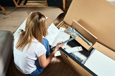 High angle view of woman sitting on table at home