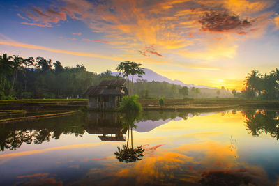 Scenic view of lake against sky at sunset