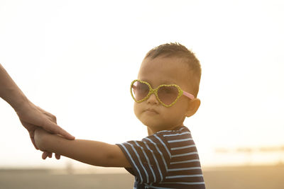 Portrait of cute boy against sky