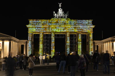 Group of people in front of historical building at night