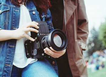 Midsection of woman photographing camera