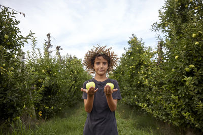 A kid wasting time in the orchard