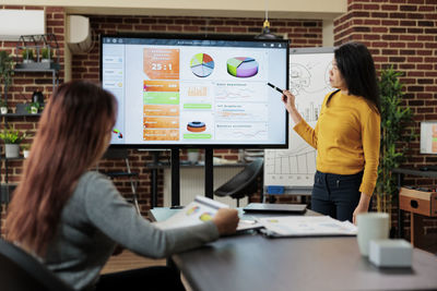 Portrait of young woman using laptop at office