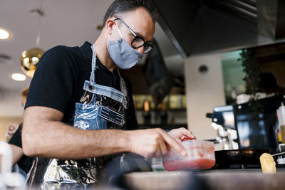 Midsection of man preparing food in kitchen