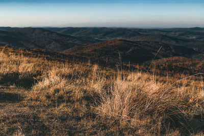 Scenic view of land and mountains against sky