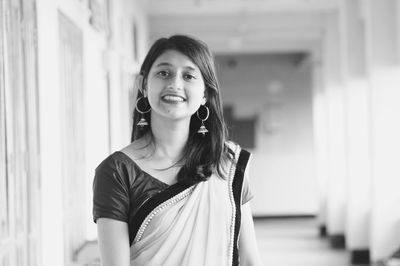 Portrait of young woman wearing sari while standing in corridor