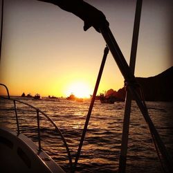 Silhouette boat sailing on sea against clear sky during sunset