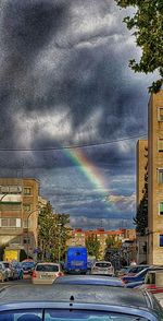 View of city street with rainbow in background