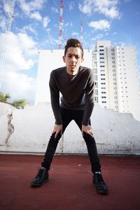 Portrait of young man standing against sky