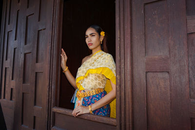 Young woman standing by door