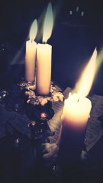 Close-up of lit tea light candles in darkroom