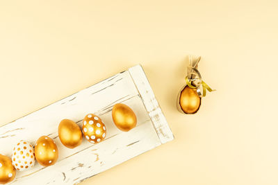 Easter festive decoration. top view of easter eggs colored with golden paint on white wooden tray.