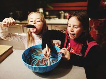 Portrait of happy girls holding bowl fukl of chocolate mousse