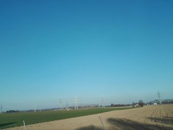 Scenic view of agricultural field against clear blue sky