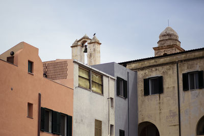 Low angle view of bell tower and buildings against clear sky