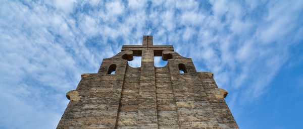 Low angle view of bell tower against cloudy sky