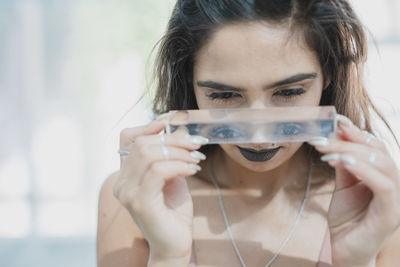 Close-up of young woman holding glass