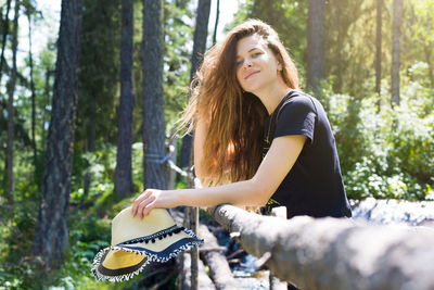 Young woman riding motorcycle in forest