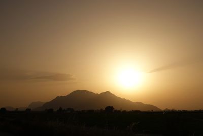 Scenic view of silhouette field against sky during sunset