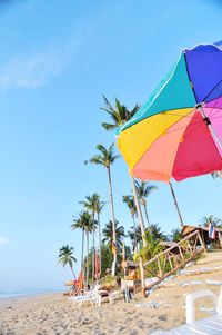 Multi colored umbrellas on beach against clear blue sky
