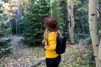Rear view of woman standing in forest