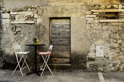 Chairs and table against window of old building