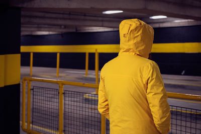 Rear view of man standing by railing