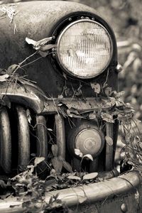 Close-up of old abandoned car on field