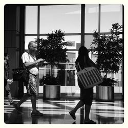 Rear view of man and woman holding umbrella