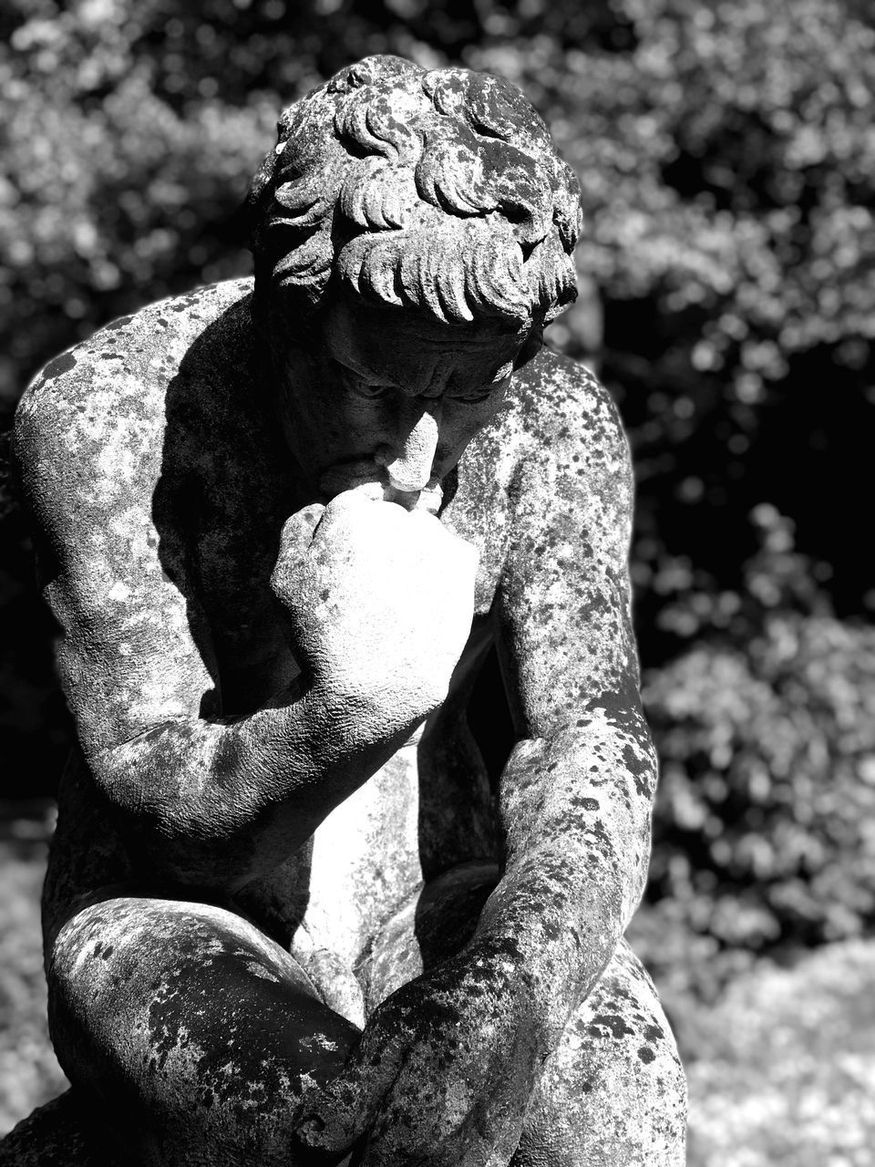 CLOSE-UP OF ANGEL STATUE AGAINST PLANTS