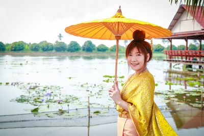 Portrait of a smiling young woman holding umbrella